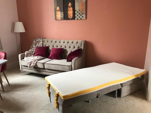 a living room with a couch and a bed at Velvet Nest 5 min walk from train station in Leamington Spa