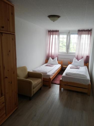 a room with two beds and a couch and window at Villa Pelso in Balatongyörök