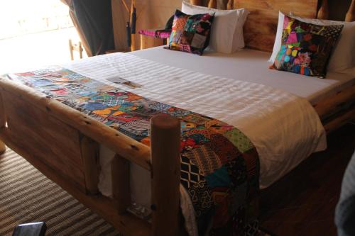 a bed in a room with a wooden bed frame at Wag Hill Lodge & Spa in Mwanza