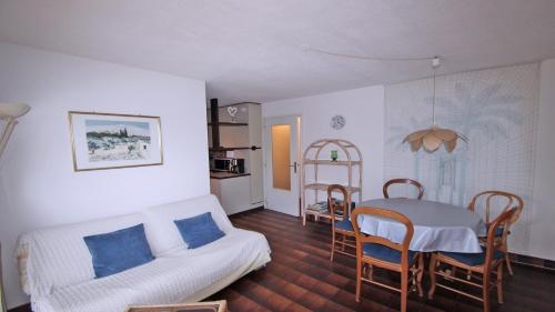 un salon avec un canapé blanc et une table dans l'établissement Les Balcons Fleuris, à Sainte-Maxime