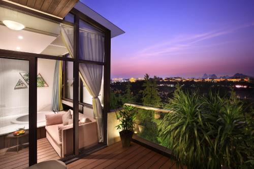 a balcony with a view of the city at night at Li River Resort Villa Hotel in Guilin