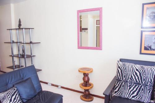 a living room with a blue couch and a mirror at High Tide Beach Condo in Durban