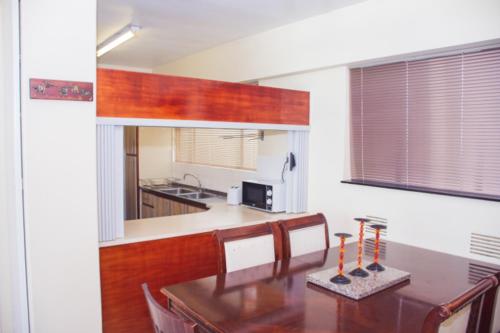 a kitchen and dining room with a table and a counter at High Tide Beach Condo in Durban