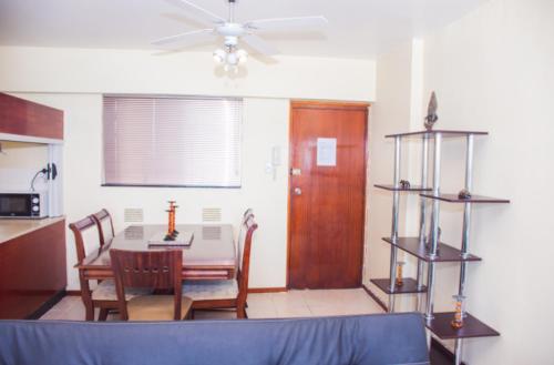 a living room with a table and chairs and a ceiling fan at High Tide Beach Condo in Durban