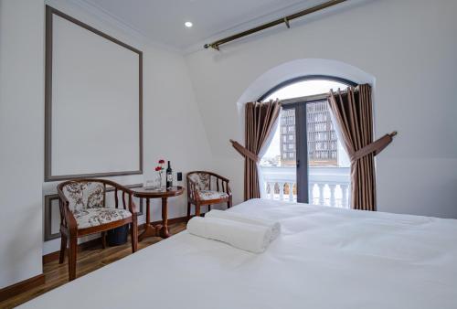 sypialnia z dużym białym łóżkiem i oknem w obiekcie Win Hotel Đà Lạt w mieście Da Lat