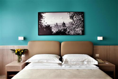 a bedroom with a bed with a blue wall at Hotel Raffaello in Florence