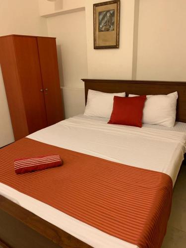 a bed with a red pillow on top of it at MJM Villa in Colombo