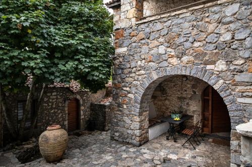 a stone wall with a table and a vase at Kanto's Guesthouse in Stemnitsa