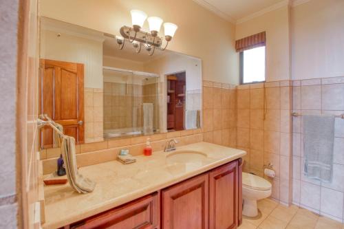 a bathroom with a sink and a toilet and a mirror at Oceanica 827 in Playa Flamingo