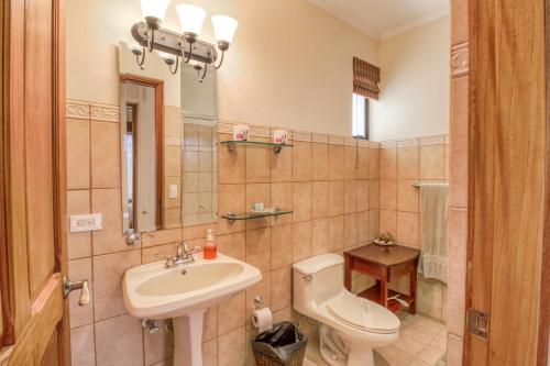 a bathroom with a sink and a toilet and a mirror at Oceanica 827 in Playa Flamingo
