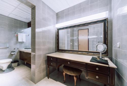 a bathroom with a mirror and a sink and a toilet at Chinggis Khaan Hotel in Ulaanbaatar