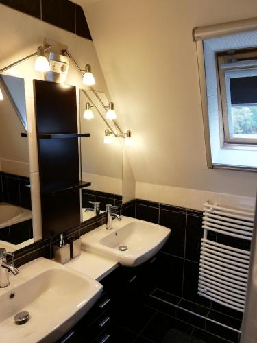 a bathroom with two sinks and a mirror at Villa Pelso in Balatongyörök