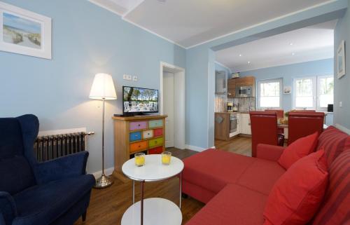- un salon avec un canapé rouge et une table dans l'établissement Strandhafer, à Boltenhagen