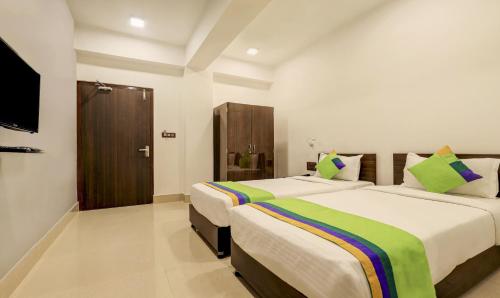 a hotel room with two beds and a flat screen tv at Treebo Arna Residency in Guwahati
