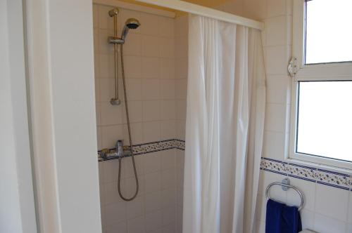 a bathroom with a shower with a shower curtain at Casa dos Amigos-cottage for 6 persons in Estói