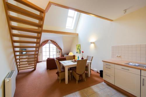 a kitchen and dining room with a table and a staircase at Ferienhäuser Dünenmeer in Dierhagen