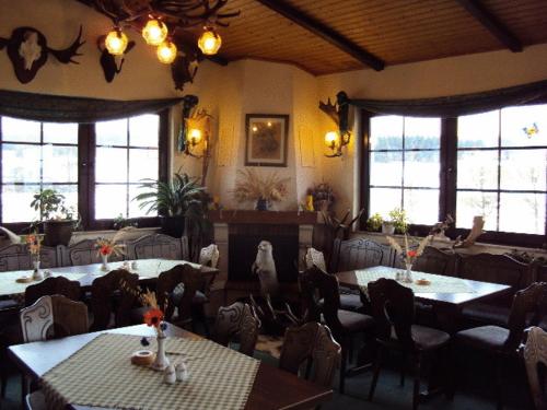 uma sala de jantar com mesas, cadeiras e janelas em Ferienwohnung im Nationalpark Jasmund em Hagen