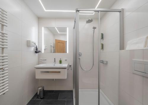 La salle de bains est pourvue d'une douche et d'un lavabo. dans l'établissement Hotel Maria, à Sils-Maria