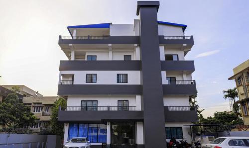 un edificio blanco alto con coches estacionados frente a él en Treebo Trend Arna Residency en Guwahati