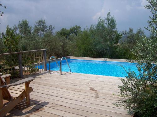 a swimming pool on a wooden deck with a bench at Villa Chiara in Pergine Valdarno