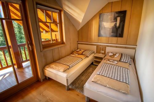 two beds in a small room with windows at Villa Salza in Sankt Martin am Grimming
