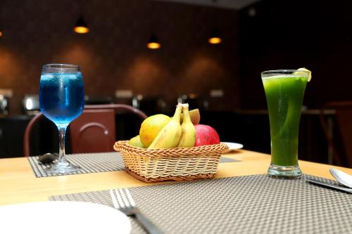 a basket of fruit on a table with a drink at Indira Nikunj Rubystone Exotic in Rishīkesh