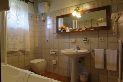 a bathroom with a sink and a toilet and a mirror at Hotel Colle Etrusco Salivolpi in Castellina in Chianti