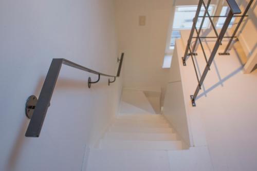 a staircase in a house with a metal railing at La Garçonnière de Wiertz - Esc'Appart in Dinant