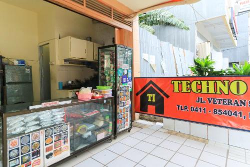 a restaurant with a sign on the side of a store at Techno Guesthouse in Makassar