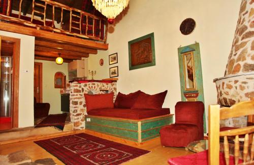 a living room with a red couch and a fireplace at Iaspis Guesthouse in Kastoria