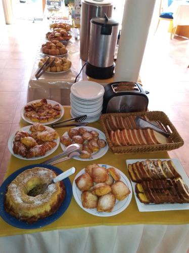 una mesa llena de diferentes tipos de comida en platos en Hotel Solar del Acuario, en Salto