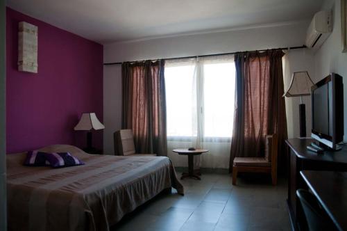 a hotel room with a bed and a window at Annexe de l'Hotel de la Poste in Diego Suarez