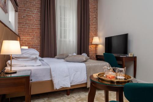 ein Hotelzimmer mit einem Bett und einem TV in der Unterkunft Luxury rooms Tilia in Zagreb