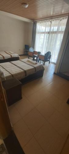 a bedroom with two beds and a chair in it at Honey Guest House in Lalībela