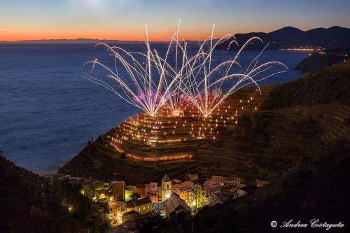 uno spettacolo di fuochi d'artificio su una collina accanto all'acqua di Posidonia Cinque Terre Guesthouse a Manarola