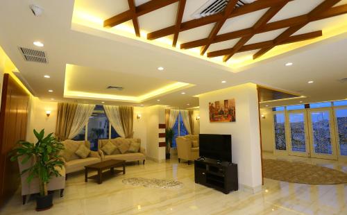 Le Paris Residency Sabah Al Salem في الكويت: غرفة معيشة مع أريكة وتلفزيون