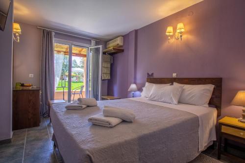 a bedroom with a large bed with towels on it at Tellis Holiday Rooms in Moraitika