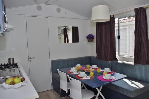 斯廷佳的住宿－Happy Camp Mobile Homes in Brioni Sunny Camping，一间厨房,里面配有蓝色的桌子和椅子