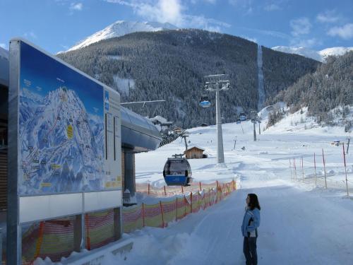 a woman standing in the snow next to a ski lift at Appartementhaus Sonnleitn in Kals am Großglockner