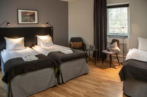 a hotel room with two beds and a window at Hotell Solhem Park in Borås