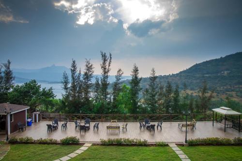 a patio with tables and chairs in a garden at Green Velvet Resort-Near Pawna Lake in Lonavala