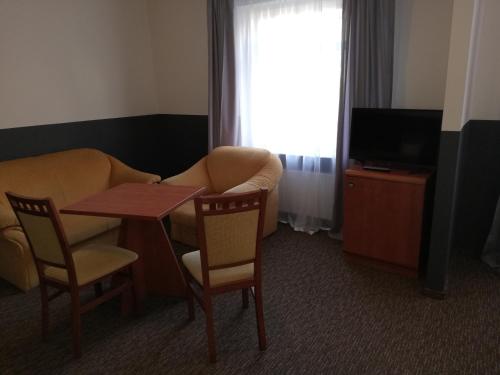 a room with a table and a couch and a television at Bristol Economy in Bytom