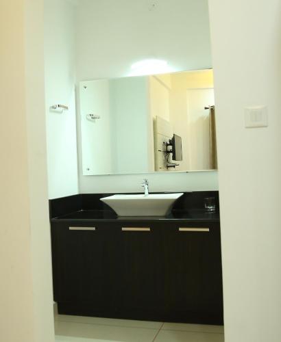 a bathroom with a sink and a mirror at Eden Isle Luxury Service Apartment in Cochin