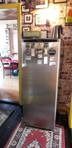 a metal refrigerator in a room with a table at Casa Mundo Bed & Breakfast in Vejle