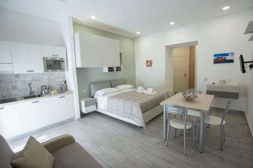 a bedroom with a bed and a table and a kitchen at La Corte dei Borboni by Dimorra in Naples