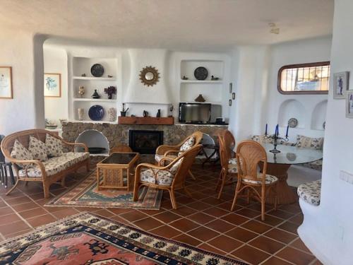 sala de estar con mesa, sillas y chimenea en Chalet El Encanto, en Zahara de los Atunes