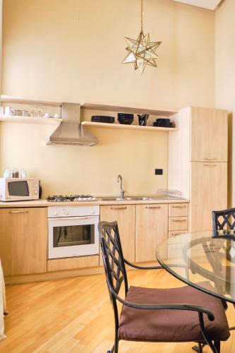 a kitchen with a glass table and a microwave at Casa Rubinacci in Naples