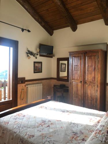 a bedroom with a bed and a tv on the wall at Agriturismo La Baita in Agerola