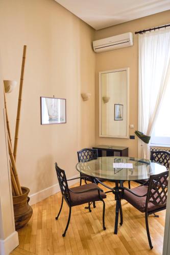 a dining room with a glass table and chairs at Casa Rubinacci in Naples