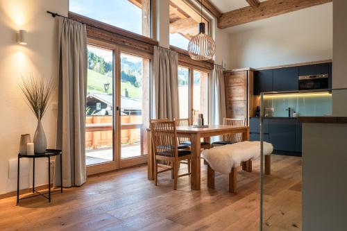 a kitchen with a wooden table and a dining room at Wagstätt Residenzen Jochberg by Alpina-Holiday in Jochberg